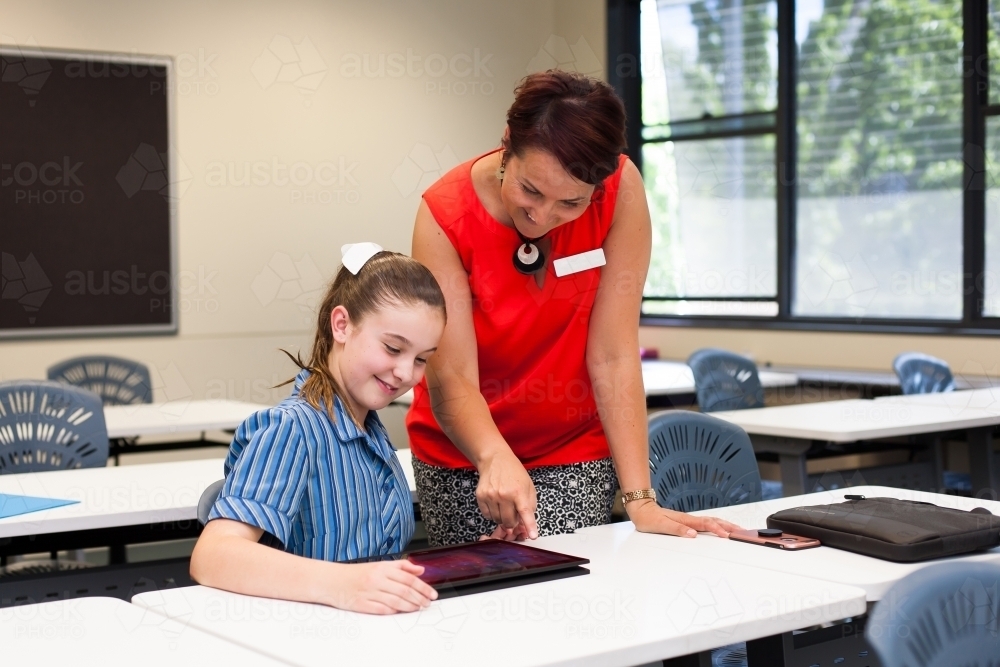 teacher helping a year 7 student in a classroom - Australian Stock Image