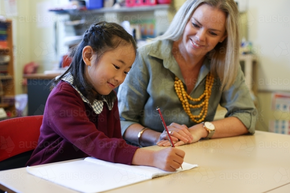Teacher helping child with  their school work - Australian Stock Image