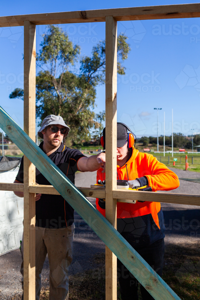 Image of teacher instructing trade apprentice on using planer tool on ...