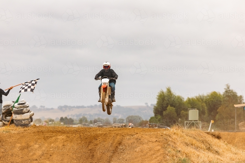 Teen boy riding motorbike at motocross track meet - Australian Stock Image