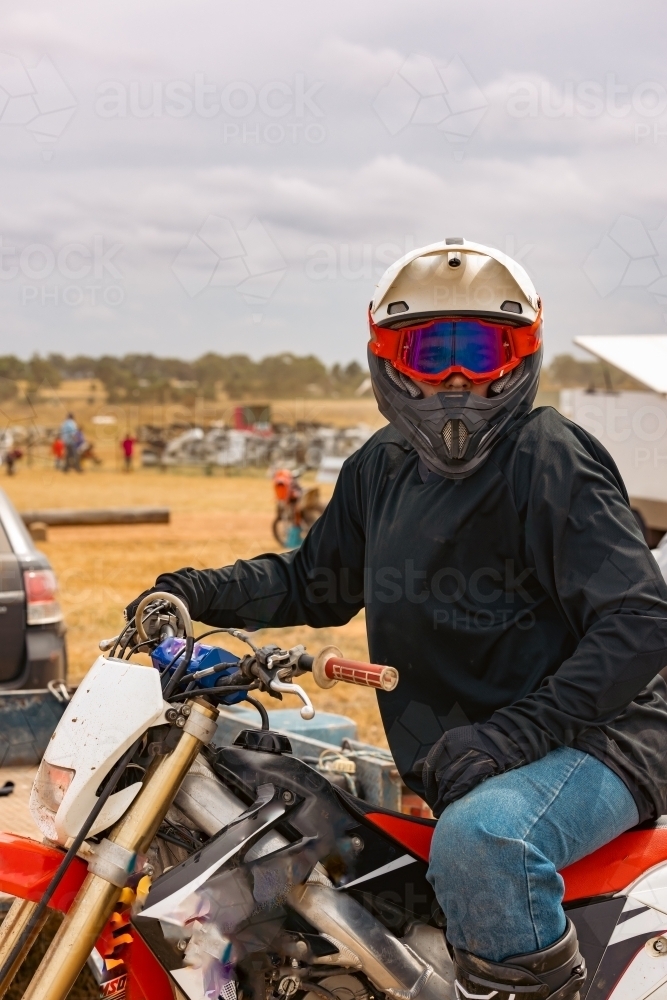 Teen boy riding motorbike at motocross track meet - Australian Stock Image
