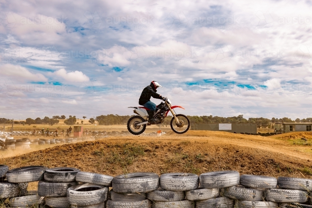 Teen boy riding motorbike at motocross track meet - Australian Stock Image