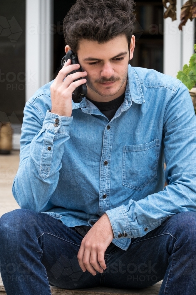 Teen boy talking on his mobile phone - Australian Stock Image