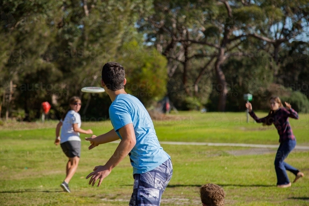 Image of Teen boy throwing frisbee for game Austockphoto