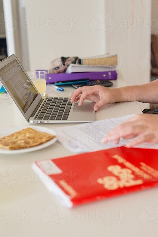 teen doing homework in the kitchen - Australian Stock Image