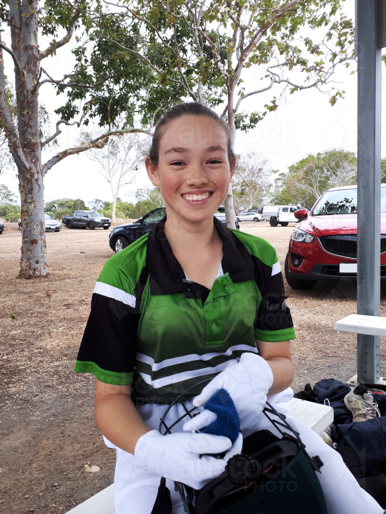 Teen female cricket player getting ready to play smiling - Australian Stock Image