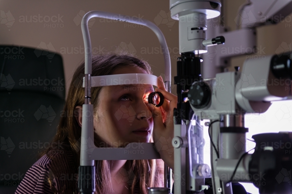 teen girl at the optometrist during an eye exam - Australian Stock Image