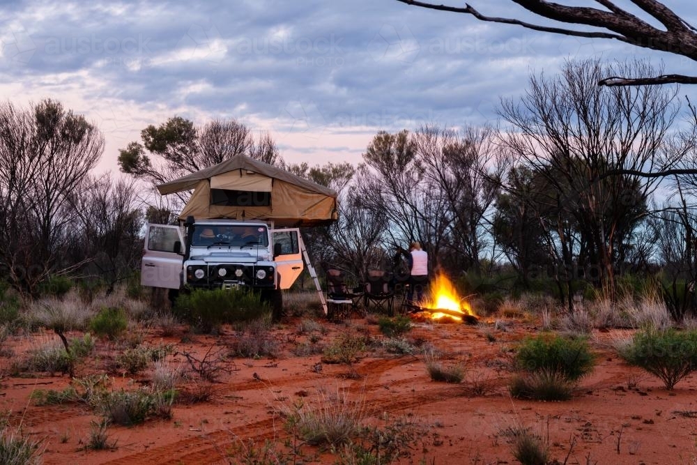 Teen girl by the fire at dusk in camp set up in outback Northern Territory - Australian Stock Image