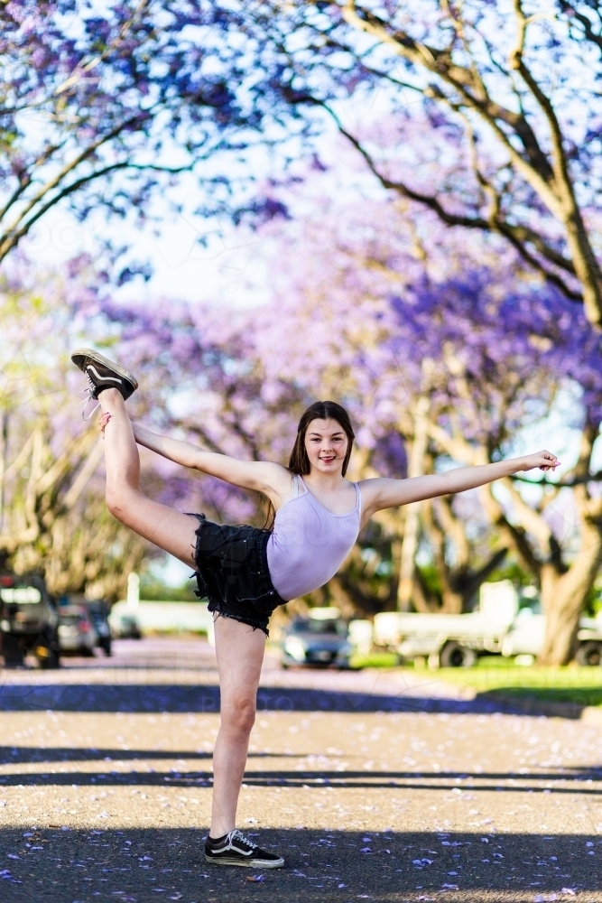 Teen girl dancer standing on the road doing a ballet pose - Australian Stock Image