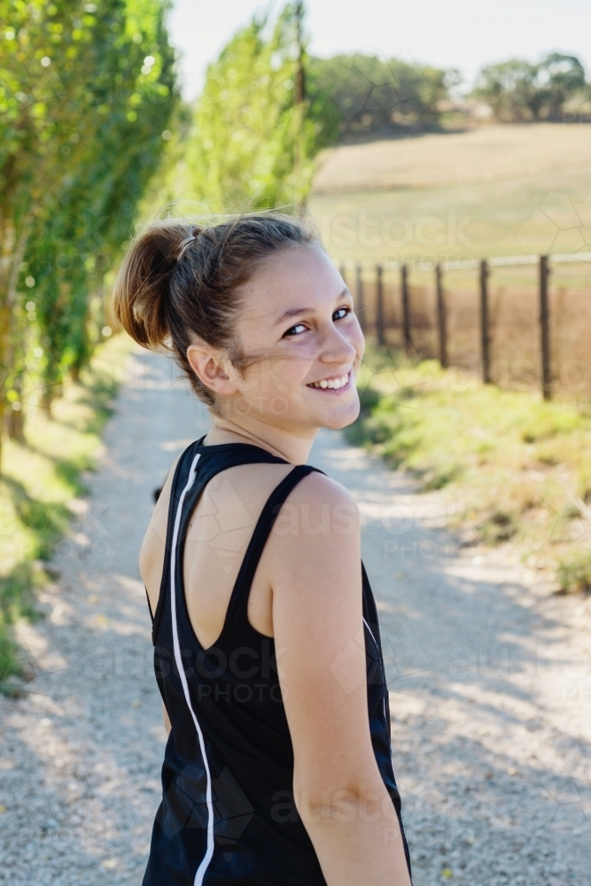 teen girl going for a morning run on a dirt road - Australian Stock Image