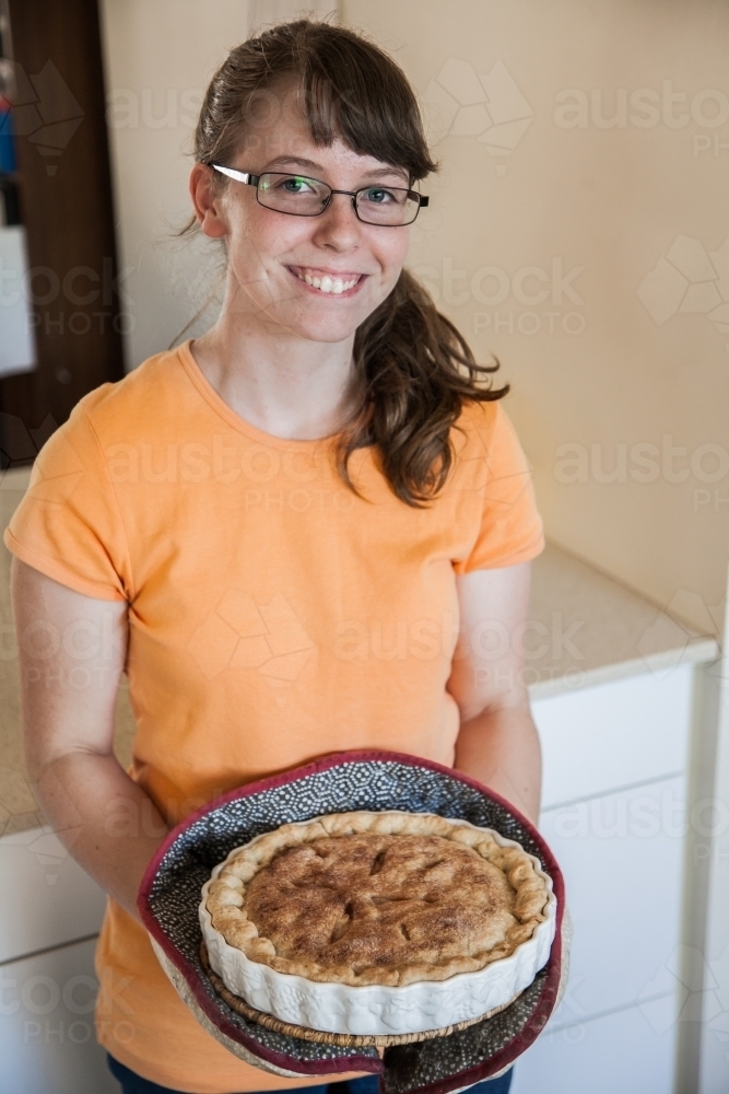Teen girl holding a freshly baked apple pie - Australian Stock Image