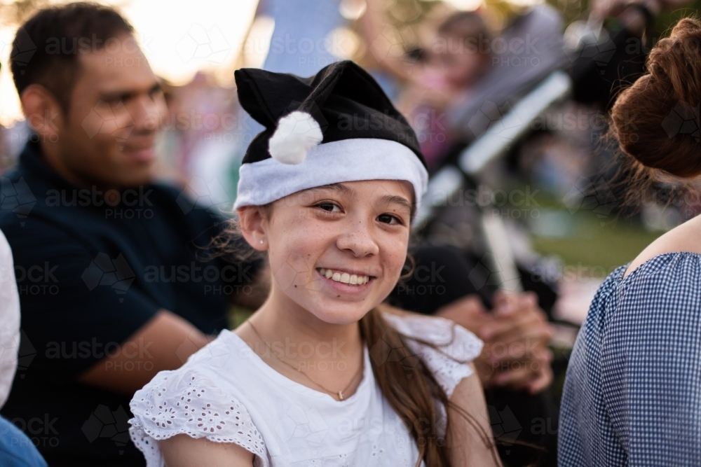 Teen girl in a black Santa hat smiling - Australian Stock Image