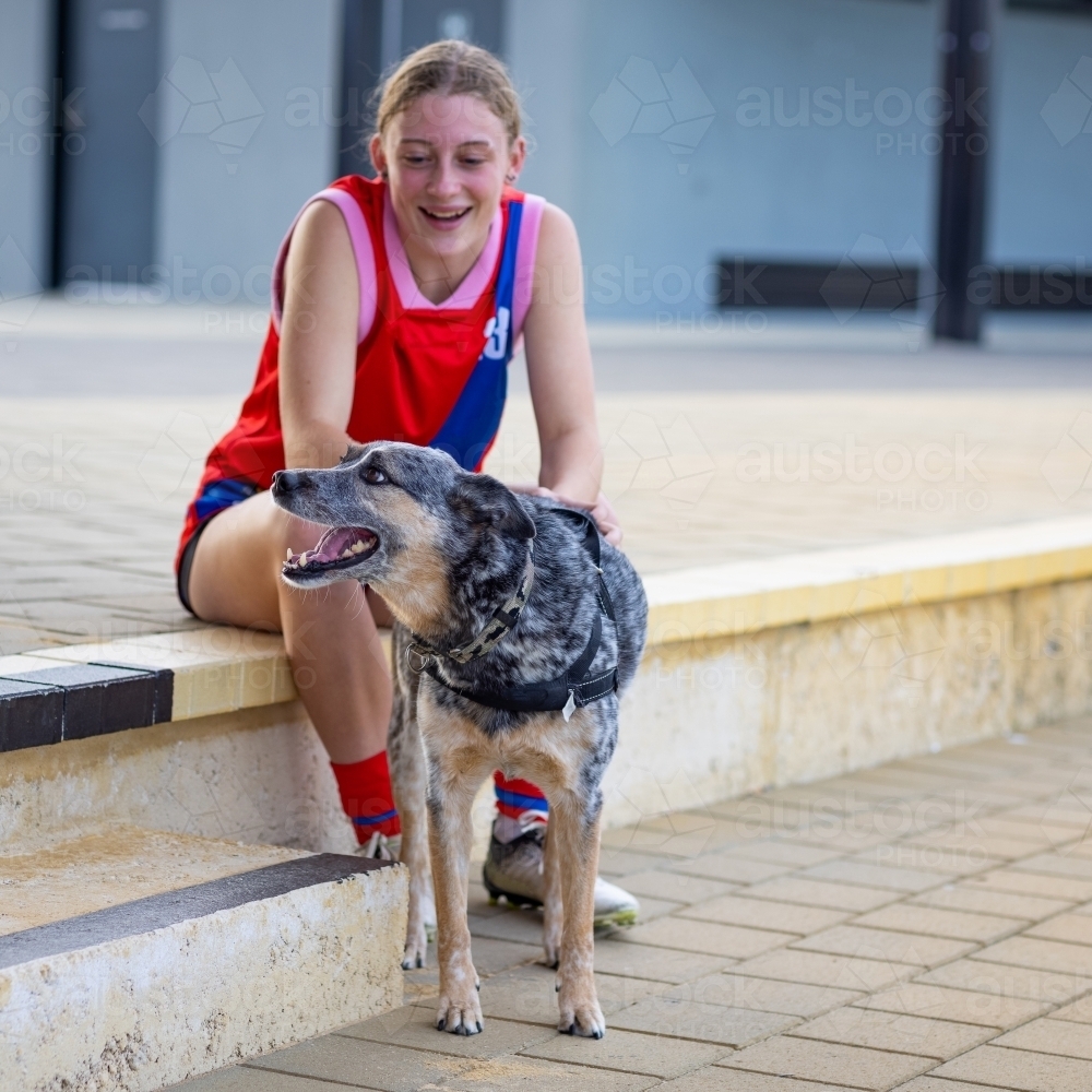 teen girl in football kit with her dog - Australian Stock Image
