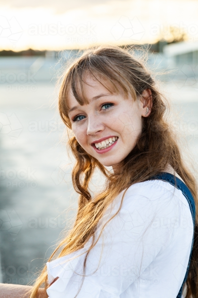 Teen girl looking over her shoulder smiling - Australian Stock Image