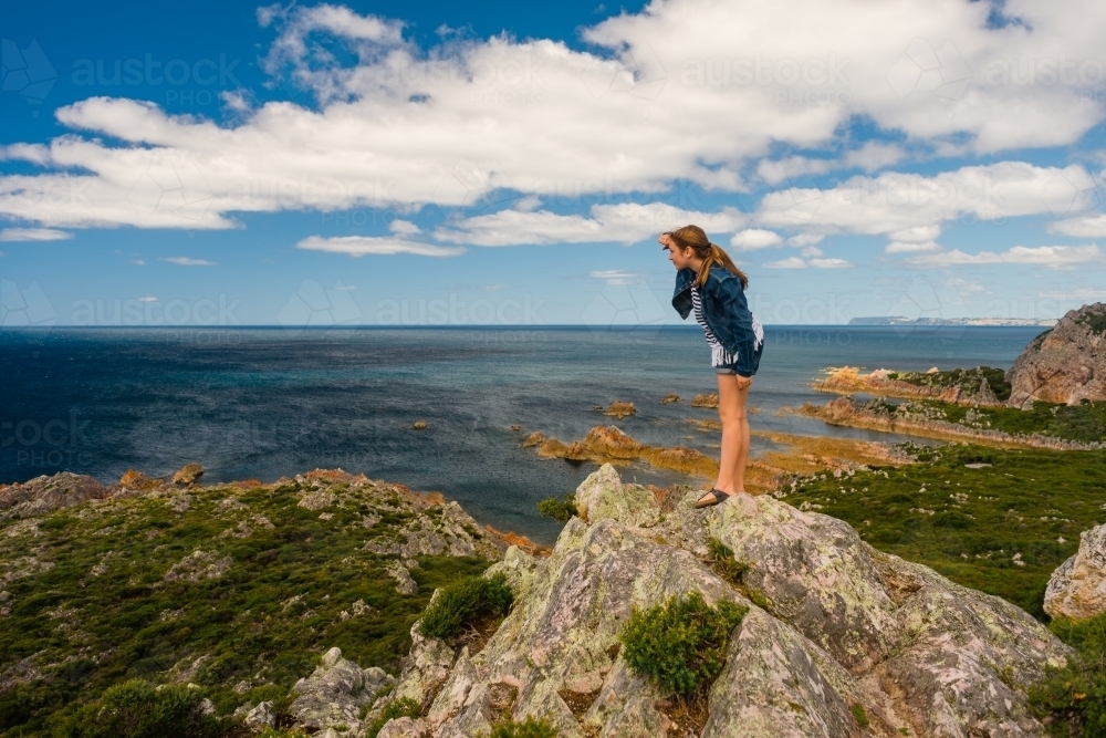 teen girl making silly pose on a cliff, Northern Tasmania - Australian Stock Image