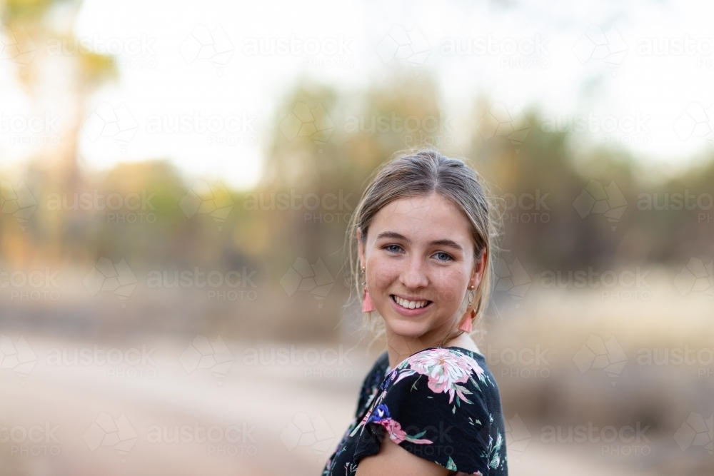 teen girl outdoors looking over shoulder - Australian Stock Image