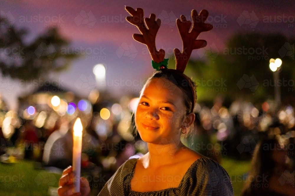 teen girl smiling at the camera at carols by candlelight - Australian Stock Image