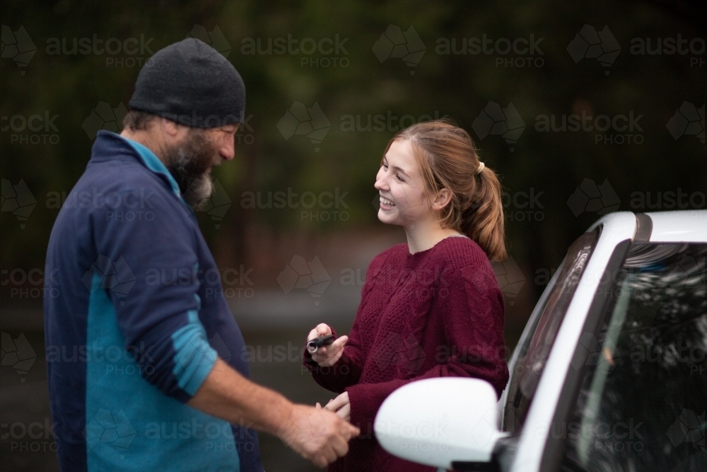 Teen girl taking car keys from her dad - Australian Stock Image
