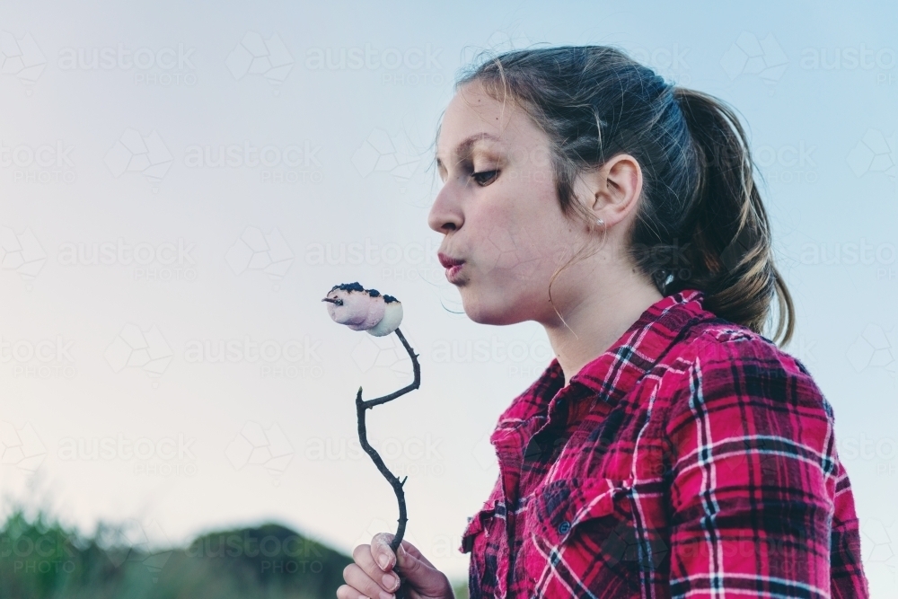 teen girl toasting marshmallows on a camping holiday - Australian Stock Image