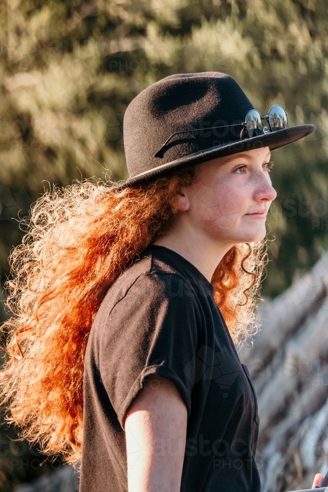 Teen girl wearing a hat profile. - Australian Stock Image