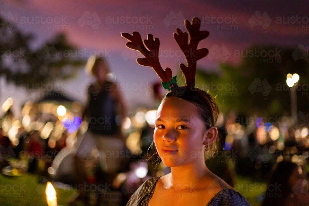 teen girl wearing antler headdress at christmas carols - Australian Stock Image