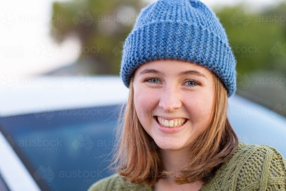 teen girl wearing hand-knitted beanie smiling - Australian Stock Image