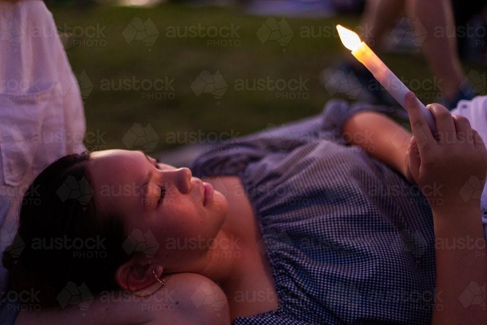 teen girl with candlelight glowing on her face - Australian Stock Image