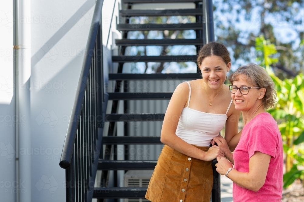 Teen girl with her mother on stairs - Australian Stock Image