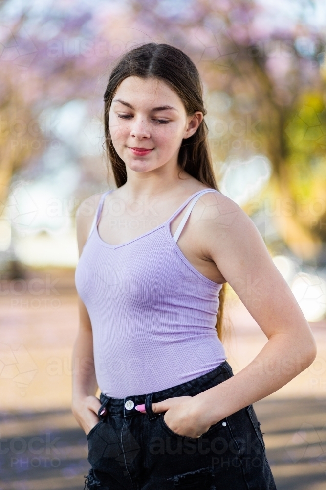 Teen girl with long hair looking down - Australian Stock Image