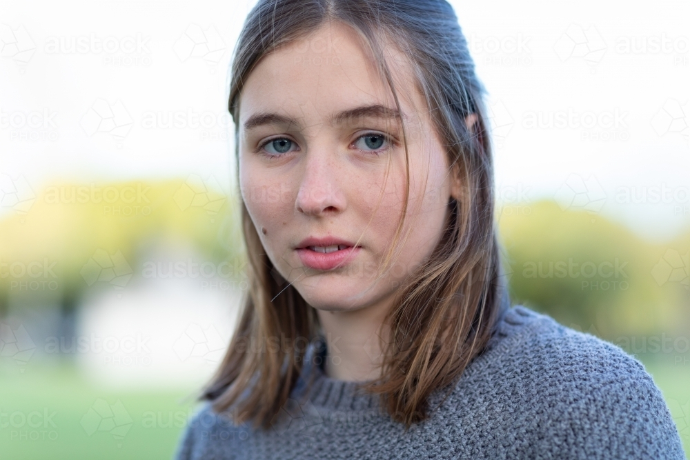teen girl with shoulder length hair looking emotionless - Australian Stock Image