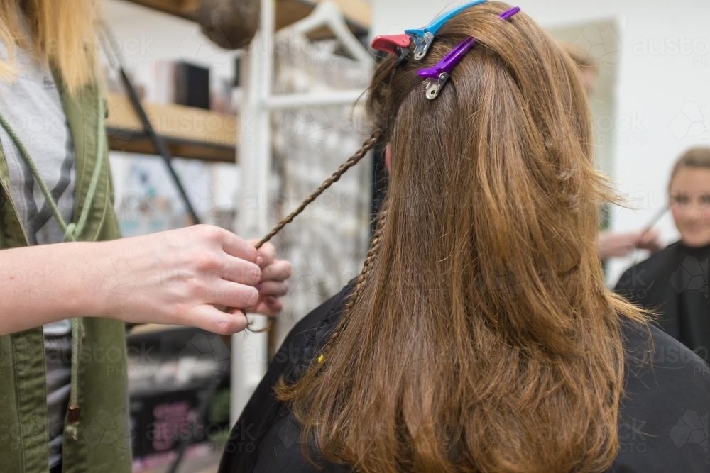 teen having hair braided at the hairdresser - Australian Stock Image