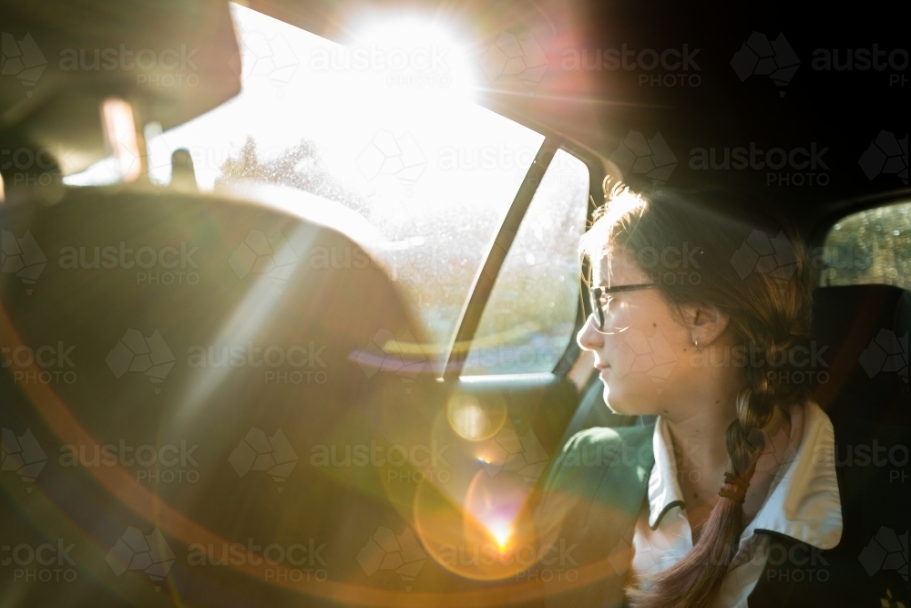 teen in school uniform, being driven to school in the morning - Australian Stock Image