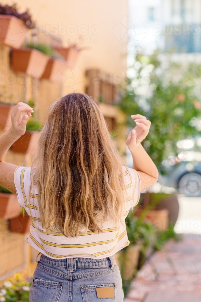 teen portrait, long hair on a teenage girl, view from behind - Australian Stock Image
