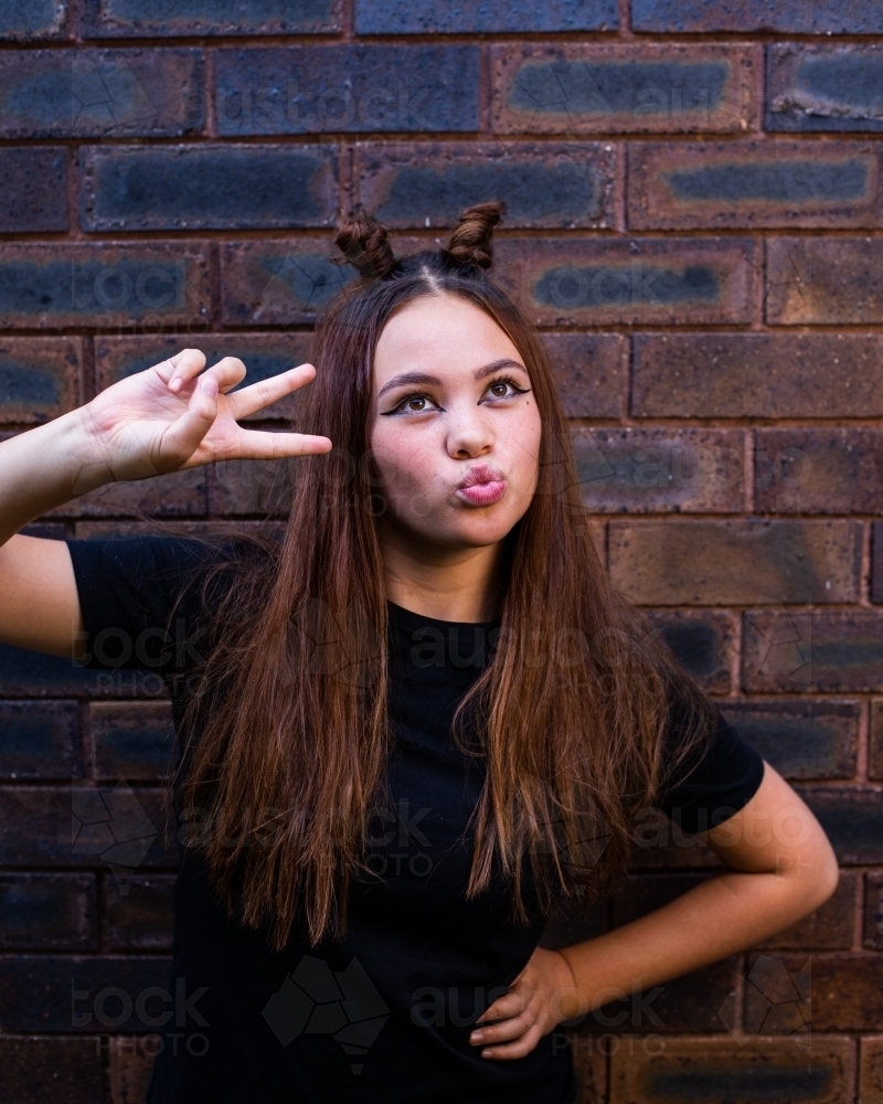 teen posing with peace sign and pout - Australian Stock Image