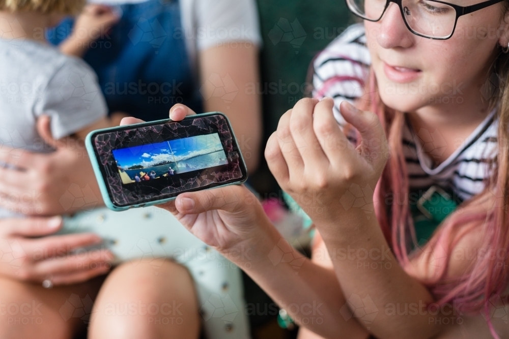 teen showing photo on her phone - Australian Stock Image