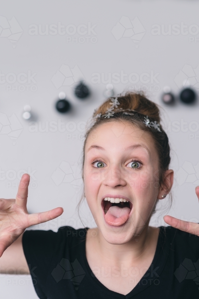 teen with hair bun and snowflakes making silly faces : Austockphoto teen with hair bun and snowflakes making silly faces - Australian Stock Image