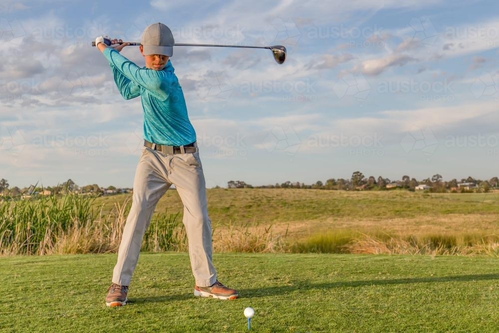 Teenage boy about to drive a golf ball from the tee - Australian Stock Image