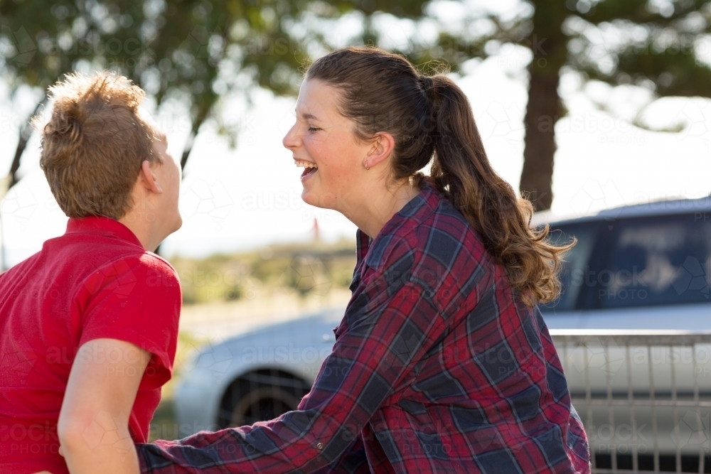Teenage boy and girl laughing together outside - Australian Stock Image