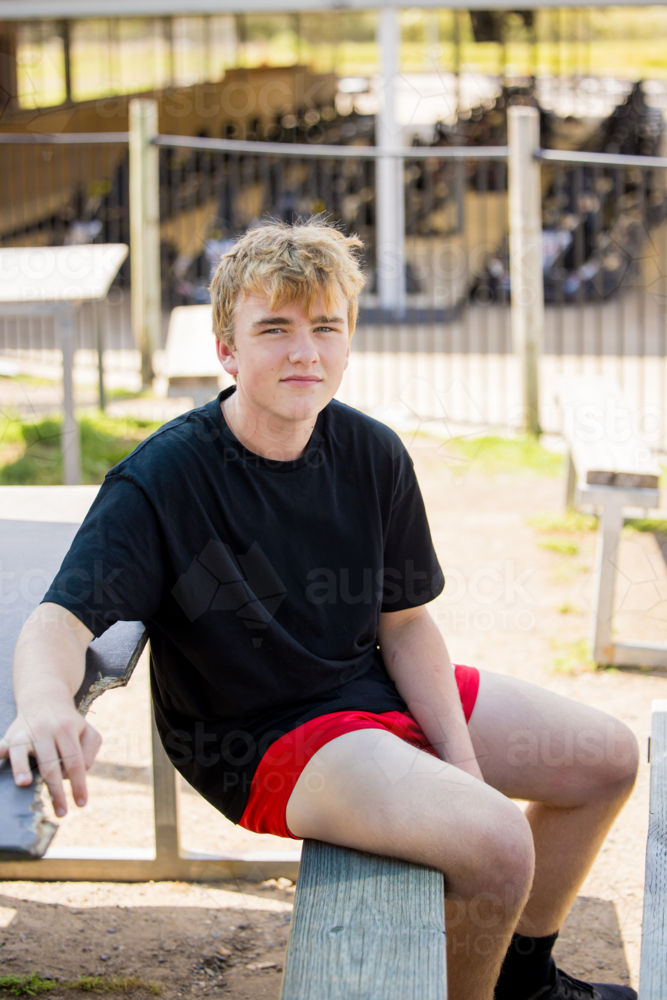 Teenage boy hanging out at outdoor go-kart track - Australian Stock Image