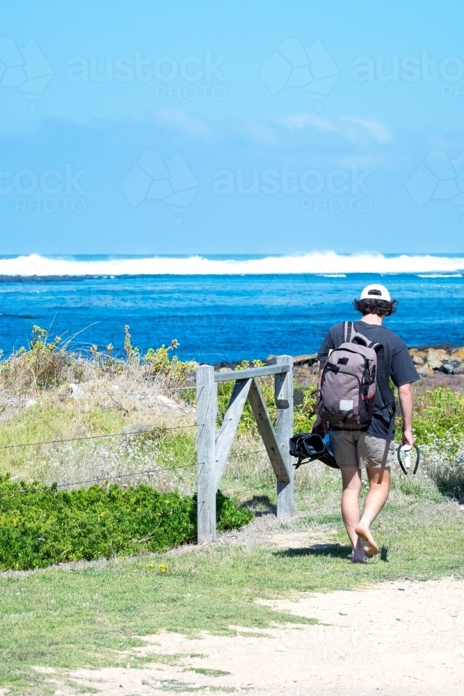 Teenage boy heading off for a snorkel at the beach - Australian Stock Image