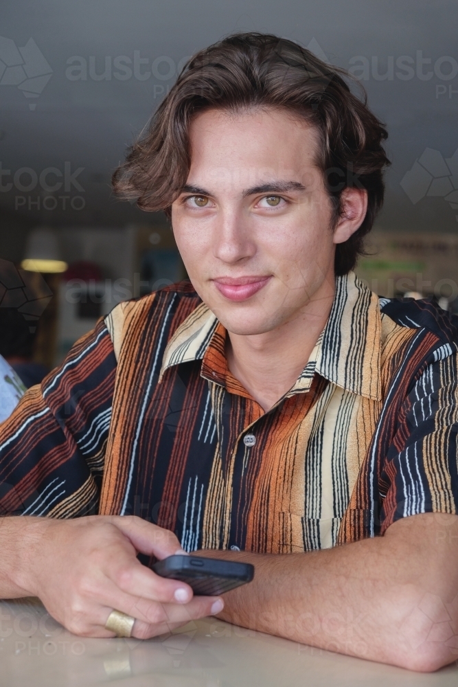 young adult boy using mobile phone - Australian Stock Image