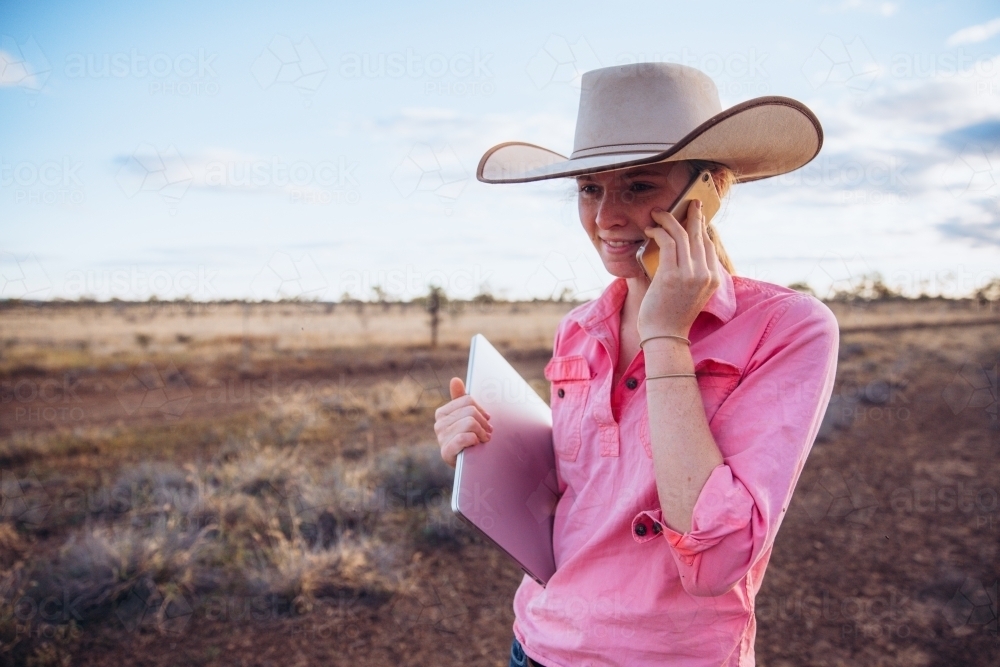 Teenage Female with smart phone and computer on the farm - Australian Stock Image