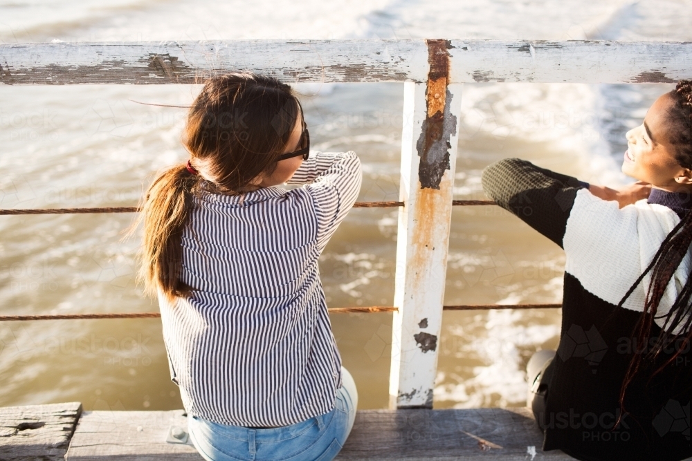 Teenage friends relaxing on a jetty - Australian Stock Image