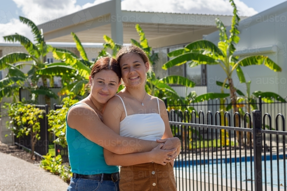 teenage friends with arms around each other - Australian Stock Image