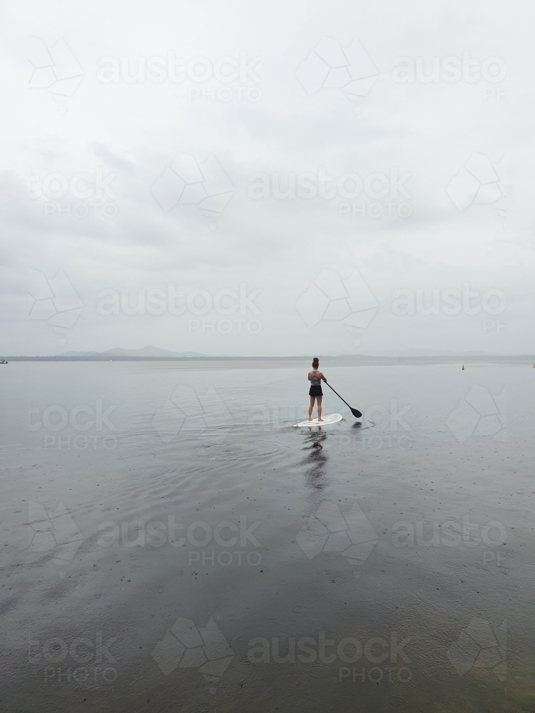 Teenage girl on a stand up paddle board - Australian Stock Image