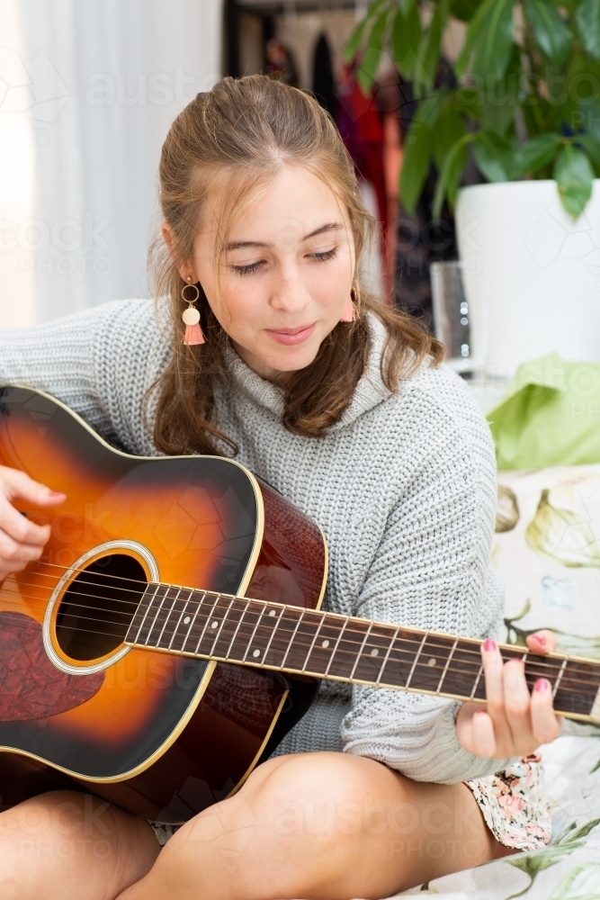 Teenage girl playing guitar - Australian Stock Image