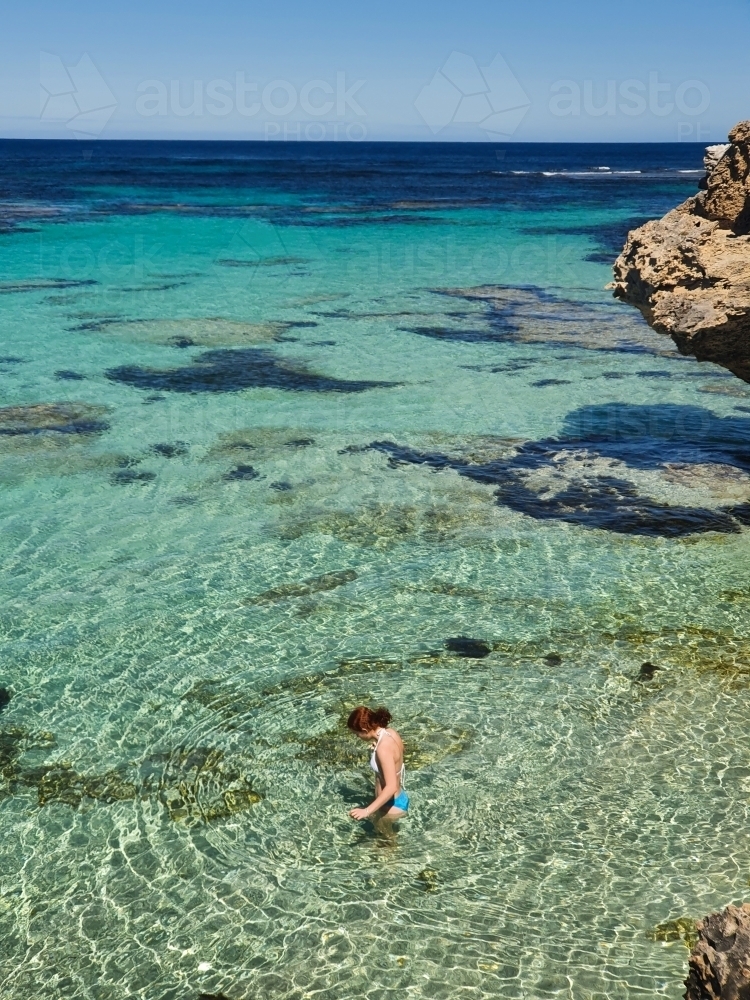 Teenage girl wading in the ocean - Australian Stock Image