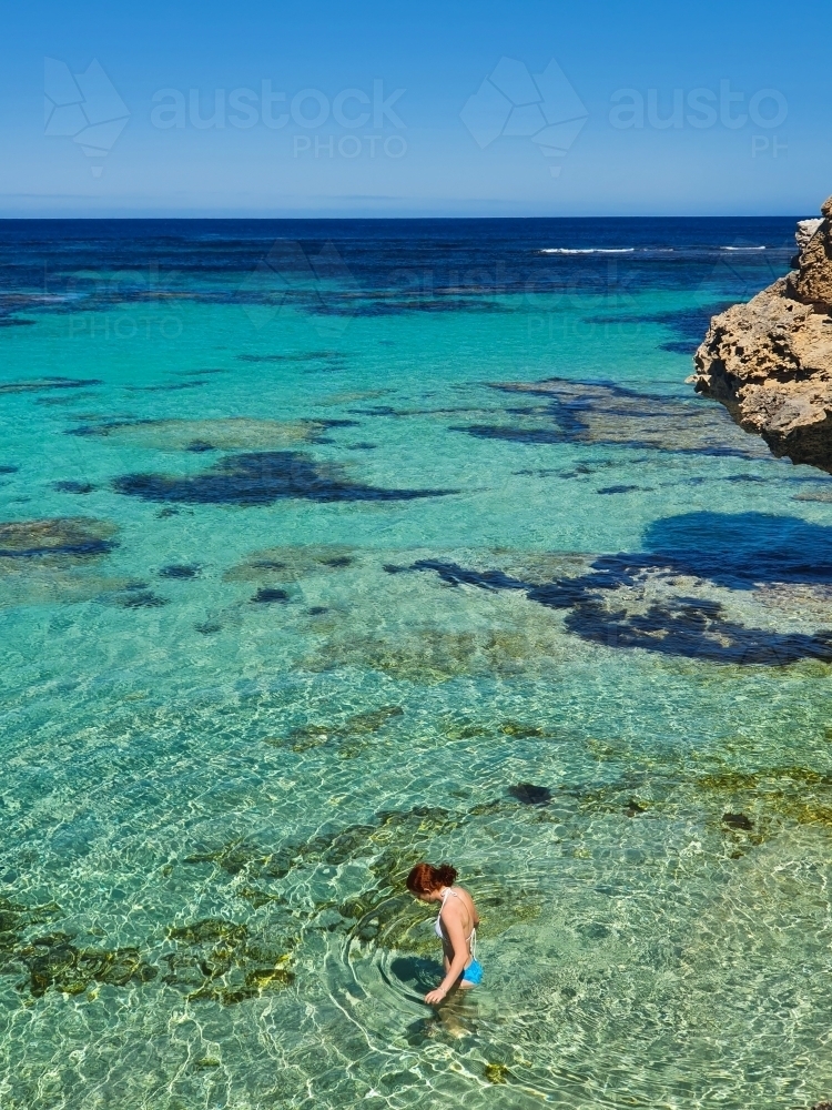 Teenage girl wading in the ocean - Australian Stock Image
