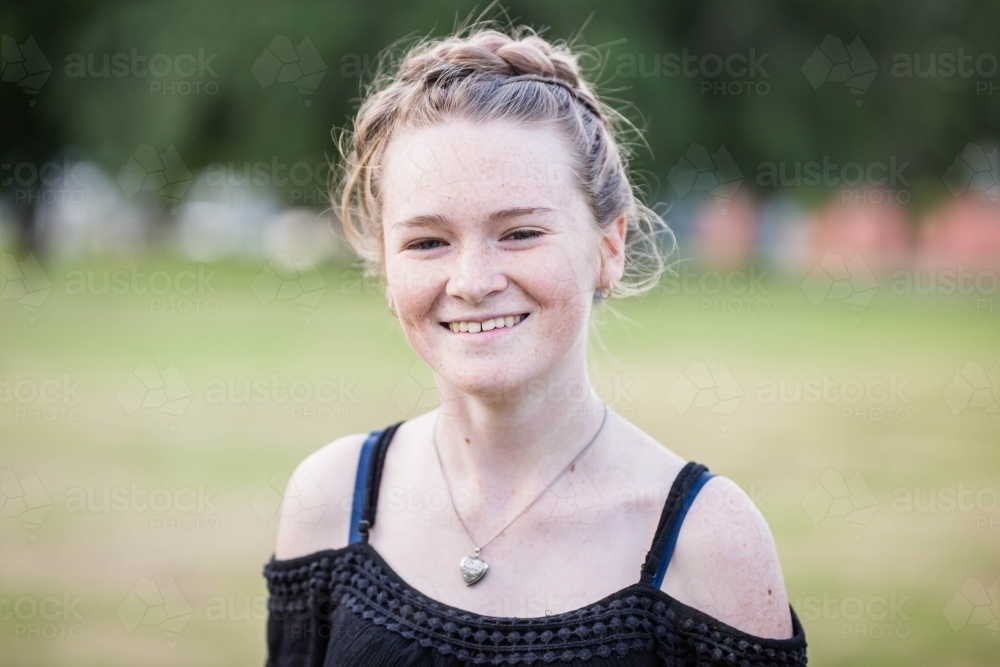 Teenage girl wearing necklace smiling - Australian Stock Image