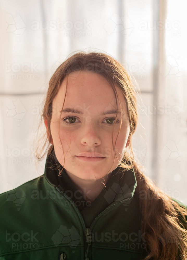 Teenage girl with long hair in winter clothes staring in portrait - Australian Stock Image